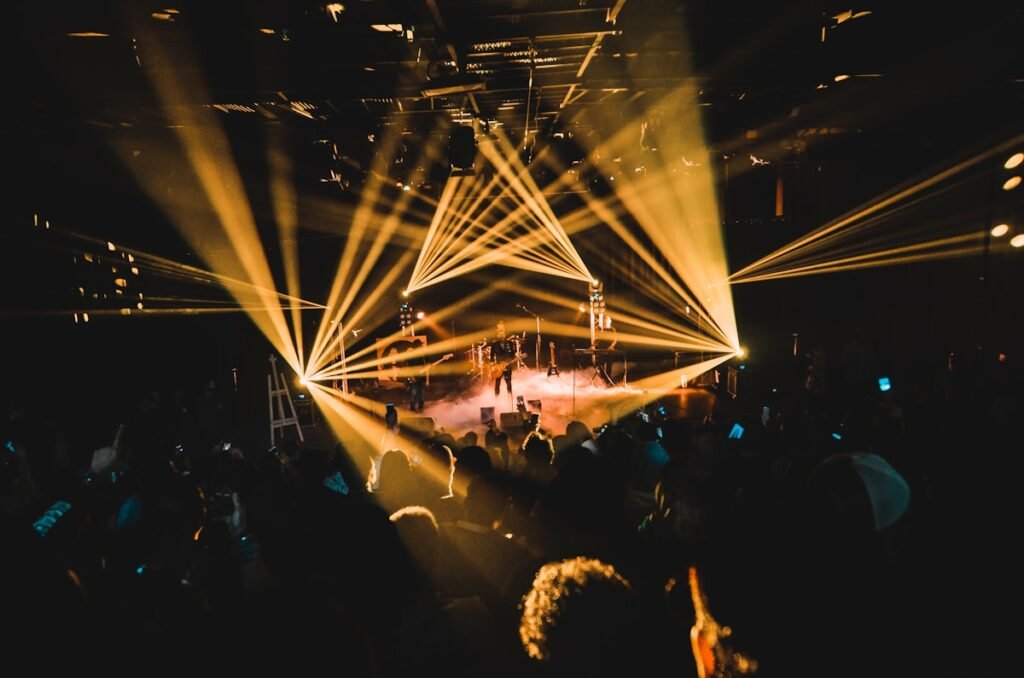 ljudi stoje i gledaju u binu punu svetla